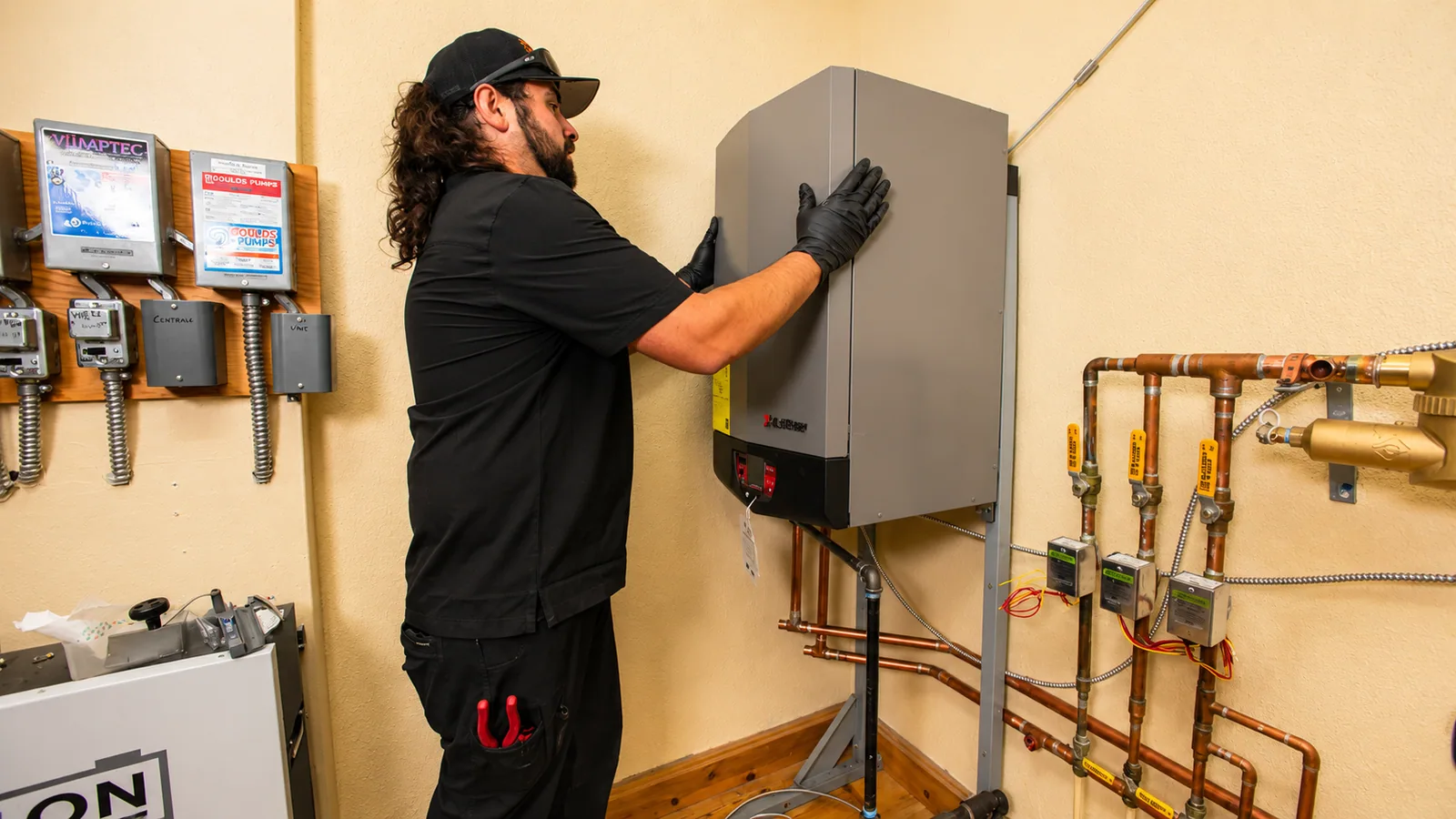 EP Plumbing, Heating & Air technician fitting the front cover of a newly installed wall-mounted boiler
