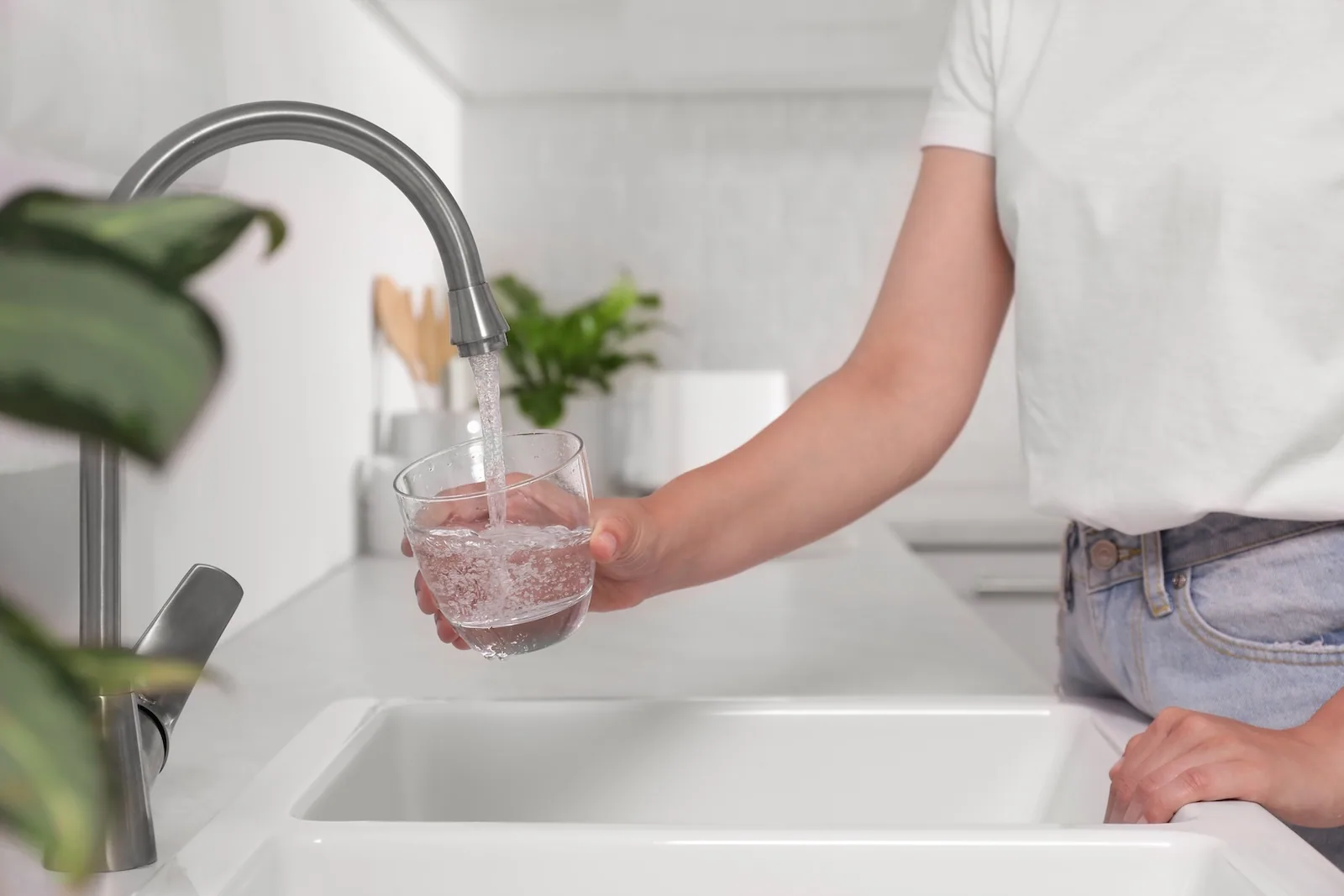 Homeowner filling a glass of filtered water at the kitchen tap